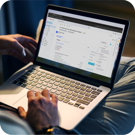 a man viewing a medical invoice within his email account on his laptop, while chatting with patient support